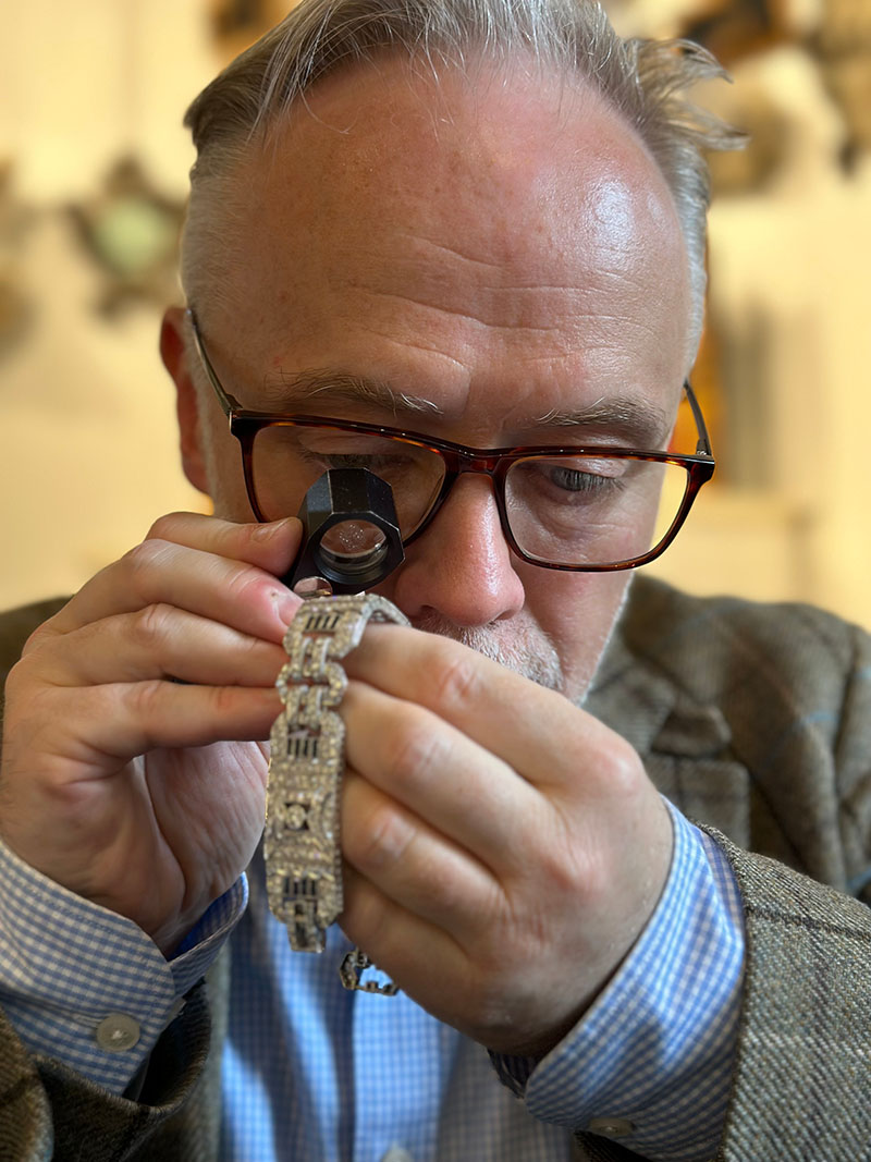 Photo of Olympia Auctions expert inspecting jewellery