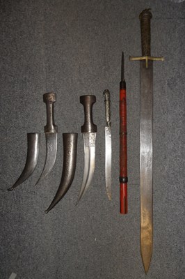 Lot 451 - A SUDANESE SWORD (KASKARA); TWO PERSIAN DAGGERS (JAMBIYA); A SHORT YATAGHAN DAGGER AND A JAPANESE SP