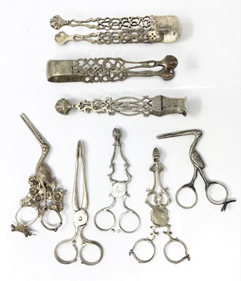 Lot 117 - A GROUP OF SIX SILVER TEA OR SUGAR TONGS AND TWO RIBBON THREADERS