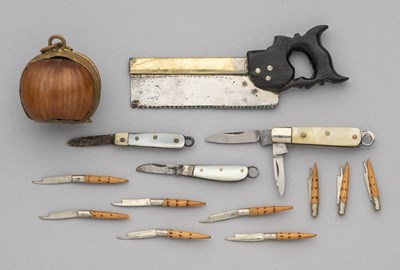 Lot 554 - A MINIATURE TENON SAW, THREE MOTHER-OF-PEARL MOUNTED MINIATURE KNIVES AND NINE MINIATURE POCKET KNIVES CONTAINED WITHIN A HAZELNUT