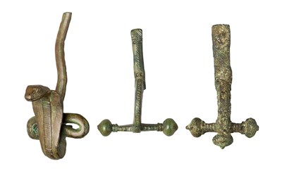 Lot 255 - â€¡ AN EGYPTIAN BRONZE ORNAMENT AND TWO ROMAN BRONZE FIBULAE
