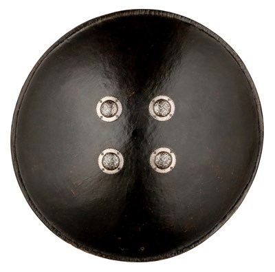 Lot 98 - A NORTH INDIAN BLACK LACQUERED BUFFALO HIDE SHIELD (DHAL), 18TH CENTURY, PROBABLY RAJASTHAN