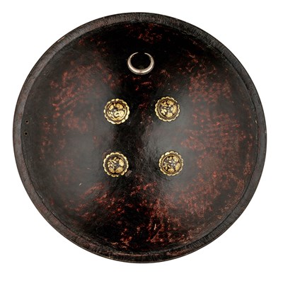 Lot 97 - A NORTH INDIAN DARK RED LACQUERED BUFFALO HIDE SHIELD (DHAL), 18TH CENTURY, PROBABLY RAJASTHAN