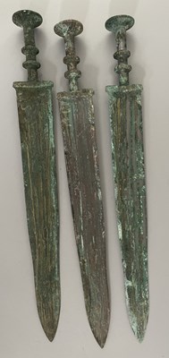 Lot 130 - A CARVED JADE SWORD HILT AND BLADE FRAGMENT IN CHINESE WARRING STATES STYLE; SIX BRONZE SWORDS (JIAN) IN CHINESE ZHOU DYNASTY OR EARLY WARRING STATES (1050-221 BC) STYLE, 20TH CENTURY