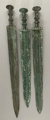 Lot 130 - A CARVED JADE SWORD HILT AND BLADE FRAGMENT IN CHINESE WARRING STATES STYLE; SIX BRONZE SWORDS (JIAN) IN CHINESE ZHOU DYNASTY OR EARLY WARRING STATES (1050-221 BC) STYLE, 20TH CENTURY