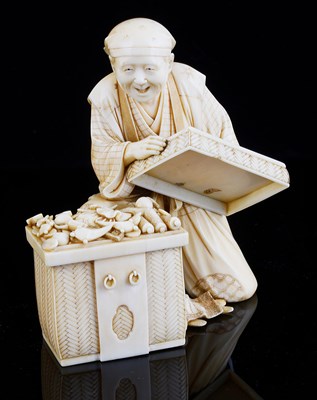 Lot 71 - ËœA JAPANESE IVORY OKIMONO OF A MAN WITH A CHEST OF TREASURES