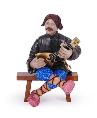 Lot 117 - A RUSSIAN STYLE CARVED HARDSTONE FIGURE OF 'THE BALALAIKA PLAYER' AFTER CARL FABERGE