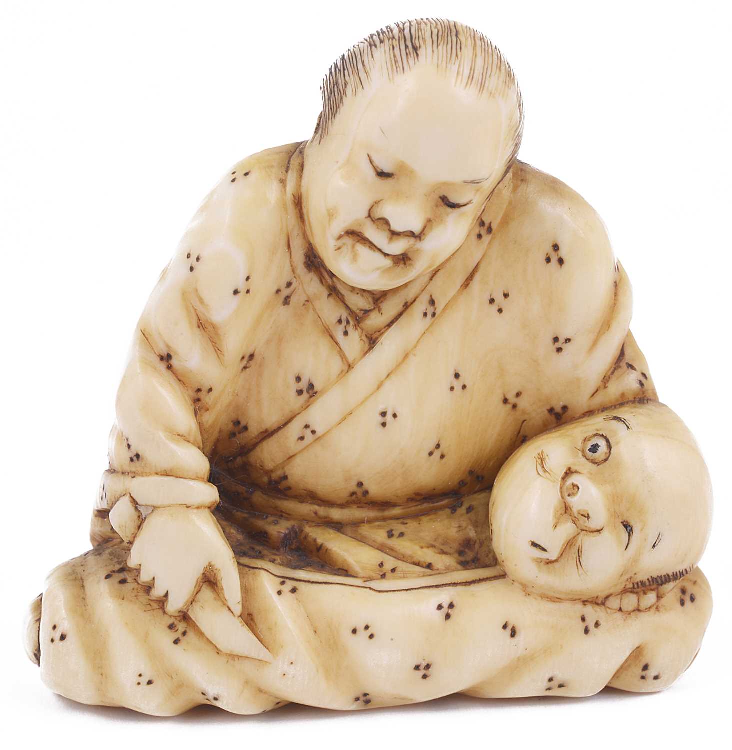 Lot 121 - ~LIGHTLY STAINED IVORY NETSUKE OF A MASK CARVER