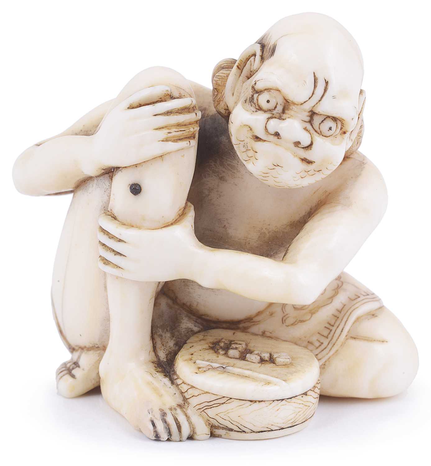 Lot 185 - ~IVORY NETSUKE OF A MAN APPLYING MOXA