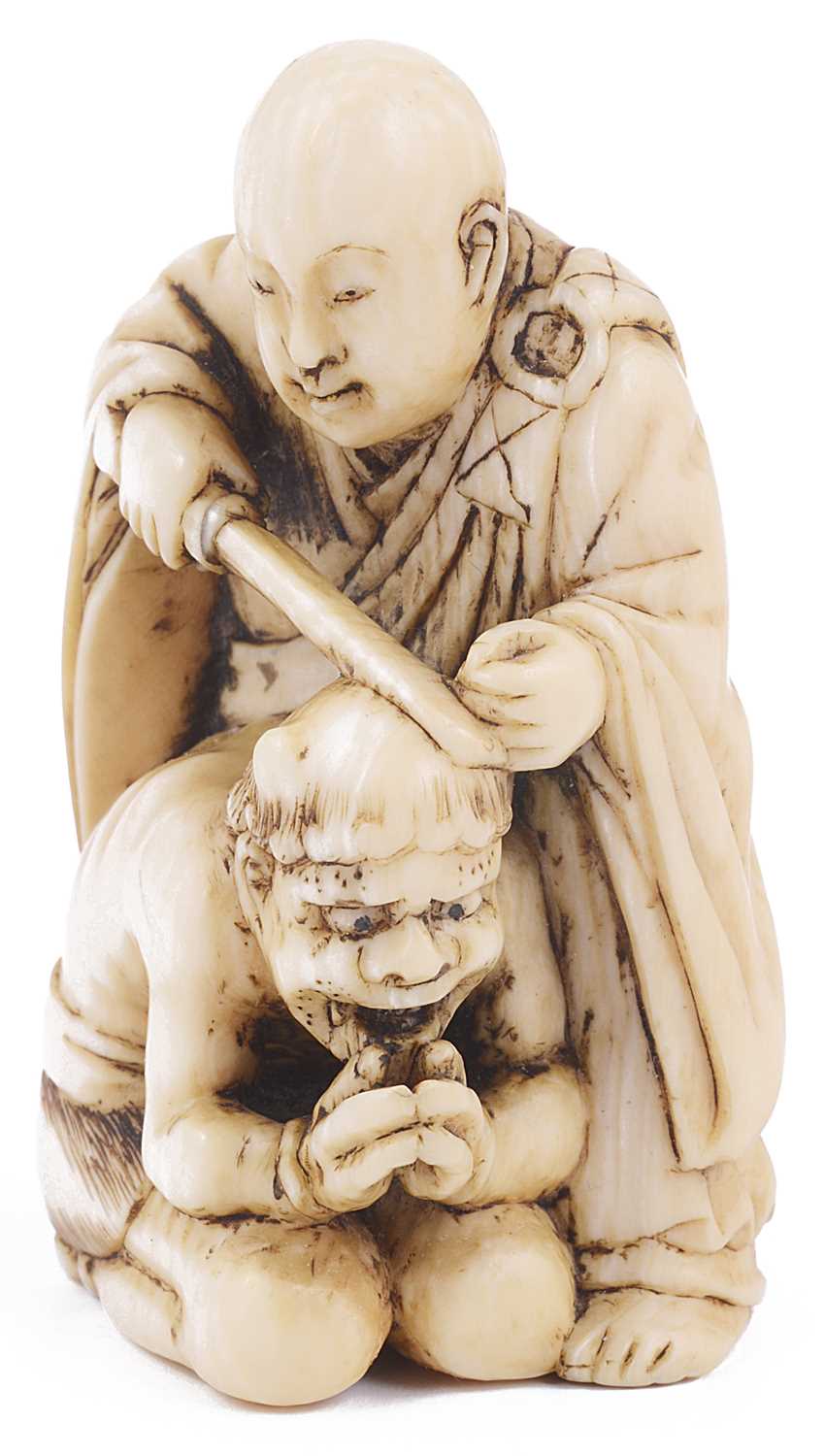 Lot 190 - ~IVORY NETSUKE OF A MONK SAWING OFF THE HORNS OF A PENITENT ONI
