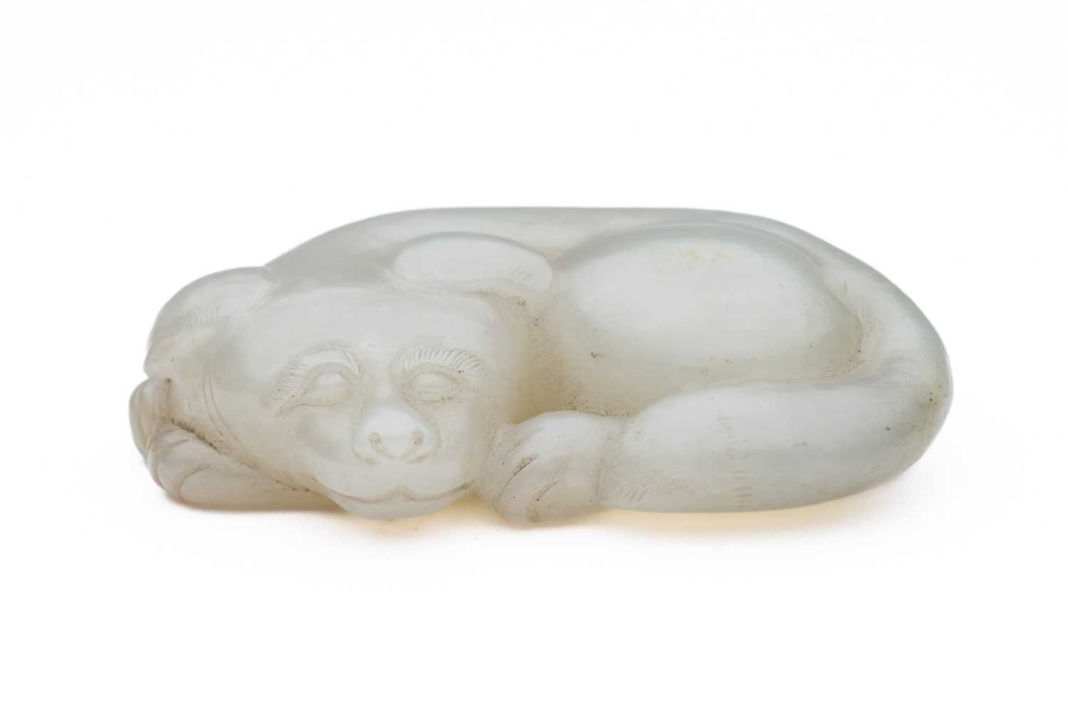 Lot 89 - A CHINESE CELADON-WHITE JADE DOG, QING DYNASTY (1644-1911)