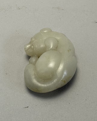 Lot 89 - A CHINESE CELADON-WHITE JADE DOG, QING DYNASTY (1644-1911)