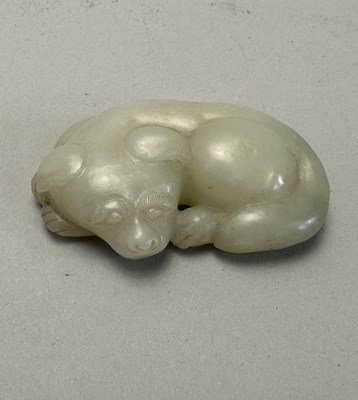 Lot 89 - A CHINESE CELADON-WHITE JADE DOG, QING DYNASTY (1644-1911)