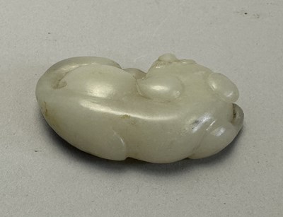 Lot 89 - A CHINESE CELADON-WHITE JADE DOG, QING DYNASTY (1644-1911)