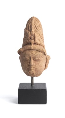 Lot 554 - A SMALL BUFF SANDSTONE HEAD OF A DEITY, RAJASTHAN OR MADHYA PRADESH, INDIA, 11TH/12TH CENTURY