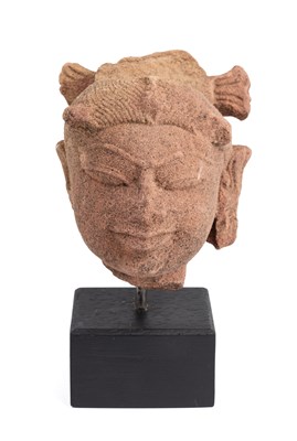 Lot 64 - A SMALL PINKISH BUFF SANDSTONE HEAD OF A DEITY