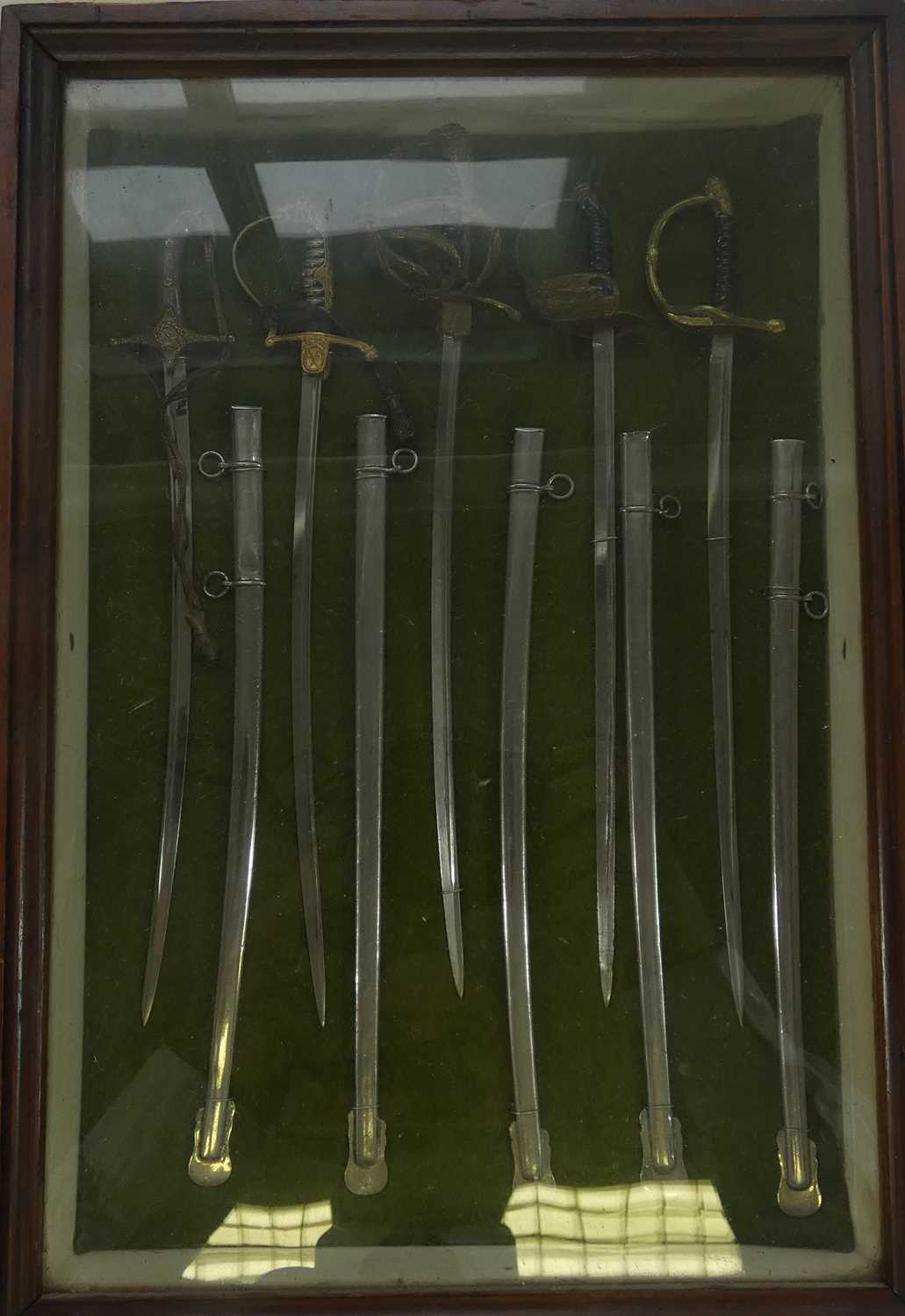 Lot 284 - A GLAZED DISPLAY OF FIVE MINIATURE GERMAN MILITARY SWORDS
