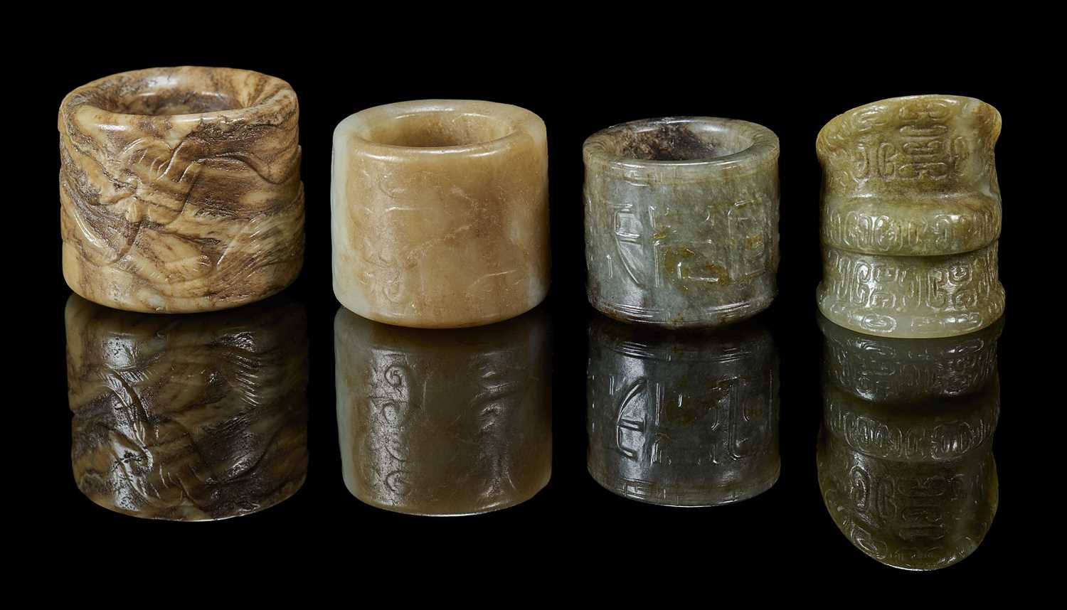 Lot 82 - FOUR CARVED JADE ARCHERS RINGS, QING DYNASTY, 19TH CENTURY