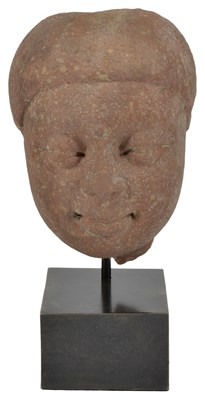 Lot 134 - A KUSHAN MOTTLED PINK SANDSTONE HEAD OF BUDDHA