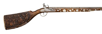 Lot 245 - AN UNUSUAL 24-BORE GERMAN FLINTLOCK GUN, EARLY 19TH CENTURY, BUILT ON AN EARLIER STOCK INLAID WITH MOTHER-OF-PEARL AND FINELY CARVED IN HIGH RELIEF, THE STOCK SIGNED JOH. EBERHARDT SOMER, CIRCA 1660