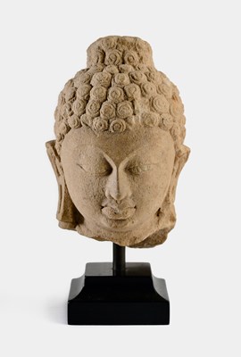 Lot 161 - A BUFF SANDSTONE HEAD OF BUDDHA OR A JINA, POST-GUPTA, CENTRAL INDIA, CIRCA 8TH CENTURY