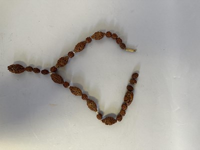Lot 7 - A CHINESE CARVED HEDIAO NUT SEED NECKLACE, QING DYNASTY, 19TH CENTURY