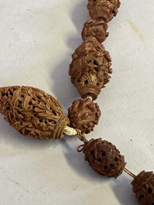 Lot 7 - A CHINESE CARVED HEDIAO NUT SEED NECKLACE, QING DYNASTY, 19TH CENTURY