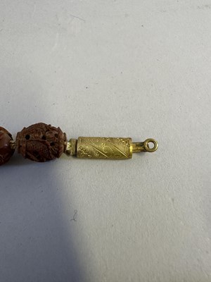 Lot 7 - A CHINESE CARVED HEDIAO NUT SEED NECKLACE, QING DYNASTY, 19TH CENTURY