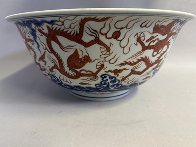 Lot 46 - A LARGE CHINESE MING-STYLE BLUE AND WHITE AND IRON-RED 'NINE DRAGON' BOWL