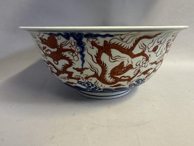 Lot 46 - A LARGE CHINESE MING-STYLE BLUE AND WHITE AND IRON-RED 'NINE DRAGON' BOWL
