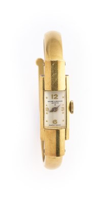 Lot 313 - BAUME ET MERCIER: A LADY'S GOLD BANGLE WATCH, CIRCA 1950