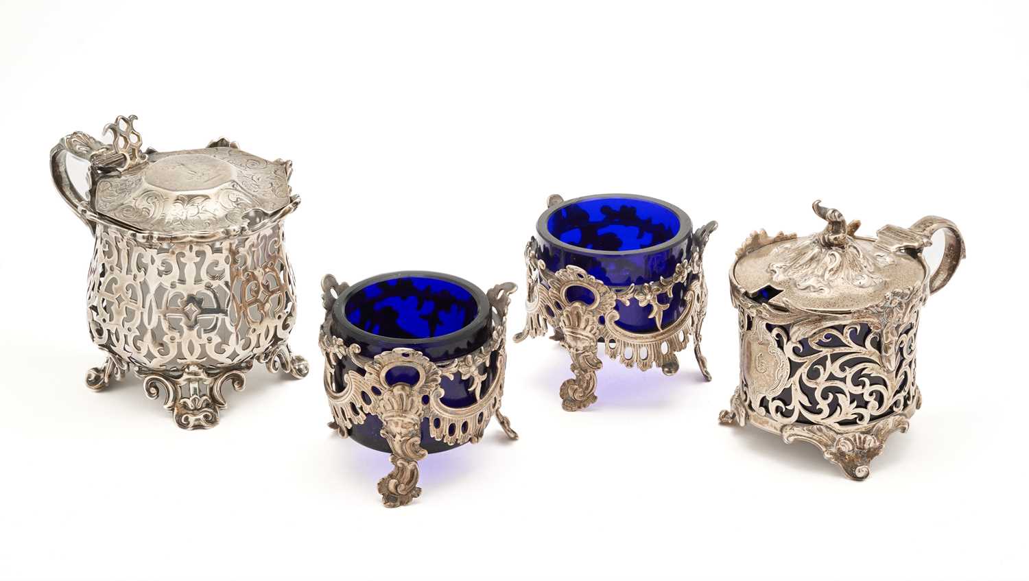 Lot 575 - A PAIR OF VICTORIAN OPENWORK SILVER SALT CELLARS AND TWO VICTORIAN OPENWORK SILVER MUSTARD POTS