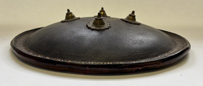 Lot 20 - AN INDIAN HIDE SHIELD (DHAL), 19TH CENTURY, SIGNED BHAGUAN KHOOSALOA, AHMEDABAD