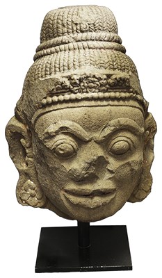 Lot 70 - A MONUMENTAL CHAM STONE HEAD OF A DVARAPALA