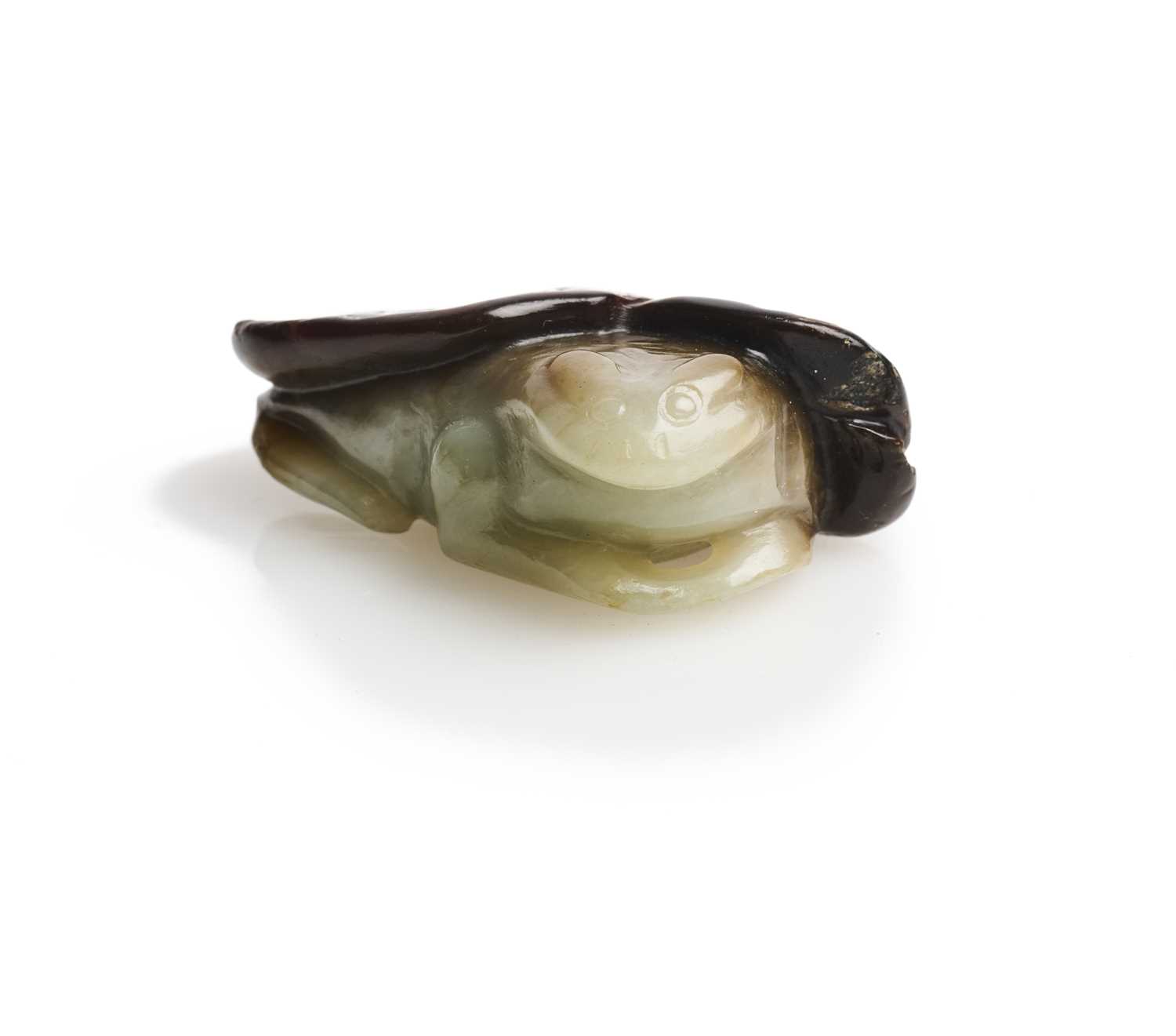 Lot 68 - A CHINESE CARVED CELADON AND RUSSET JADE 'FROG AND LOTUS' GROUP, QING DYNASTY (1644-1911)