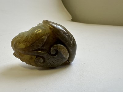 Lot 69 - A CHINESE CELADON AND BROWN JADE CARVING OF A BOY AND LOTUS, QING DYNASTY (1644-1911)