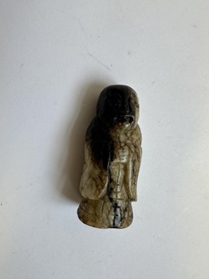 Lot 65 - A CHINESE CREAM AND BLACK JADE FIGURE, MING DYNASTY (1368-1644)