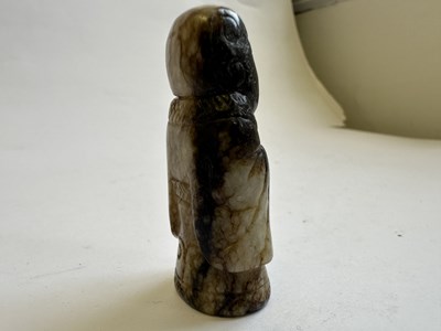 Lot 65 - A CHINESE CREAM AND BLACK JADE FIGURE, MING DYNASTY (1368-1644)