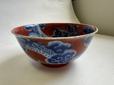 Lot 12 - A CHINESE RED-GROUND BLUE AND WHITE 'DRAGON' BOWL, QING DYNASTY, KANGXI PERIOD (1662-1722)