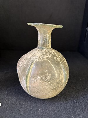 Lot 66 - A ROMAN PALE GREEN GLASS SPRINKLER FLASK, CIRCA 3RD-4TH CENTURY A.D.