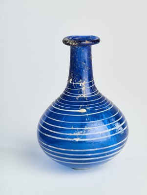 Lot 219 - A COBALT BLUE GLASS BOTTLE, ROMAN, CIRCA 1ST CENTURY A.D.