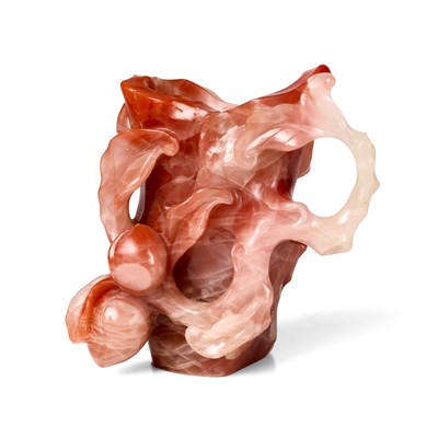 Lot 18 - A CHINESE ROSE AGATE 'LOTUS AND PEACH' LIBATION CUP, 20TH CENTURY