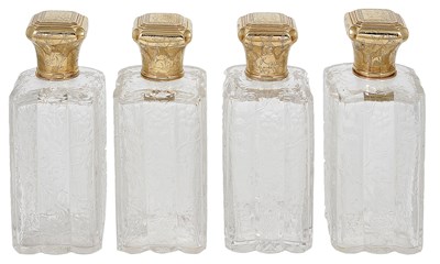 Lot 391 - A SET OF FOUR LARGE GEORGE V GOLD-MOUNTED AND COVERED GLASS TOILET BOTTLES