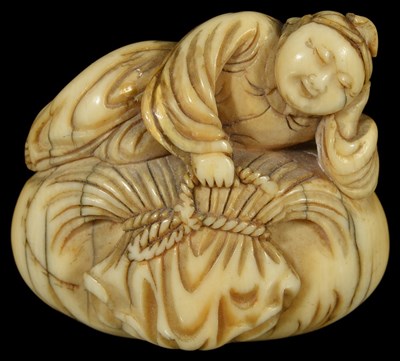 Lot 356 - ~A JAPANESE IVORY NETSUKE OF A BOY ON HOTEI'S SACK