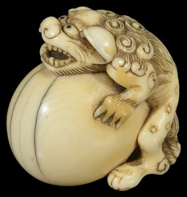 Lot 357 - ~A JAPANESE IVORY NETSUKE OF A SHISHI