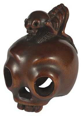 Lot 374 - ~A JAPANESE EBONY NETSUKE OF A SKELETON ON A HUMAN SKULL