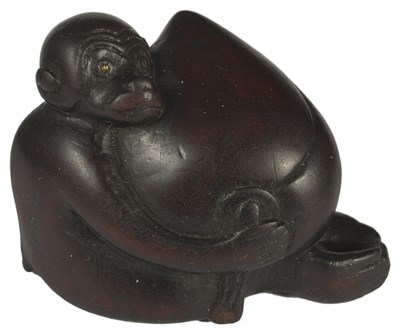 Lot 385 - A JAPANESE WOOD NETSUKE OF A MONKEY HUGGING A HUGE PEACH