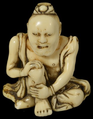 Lot 429 - ~A JAPANESE IVORY NETSUKE OF A NIO BY IKKOSAI TOUN